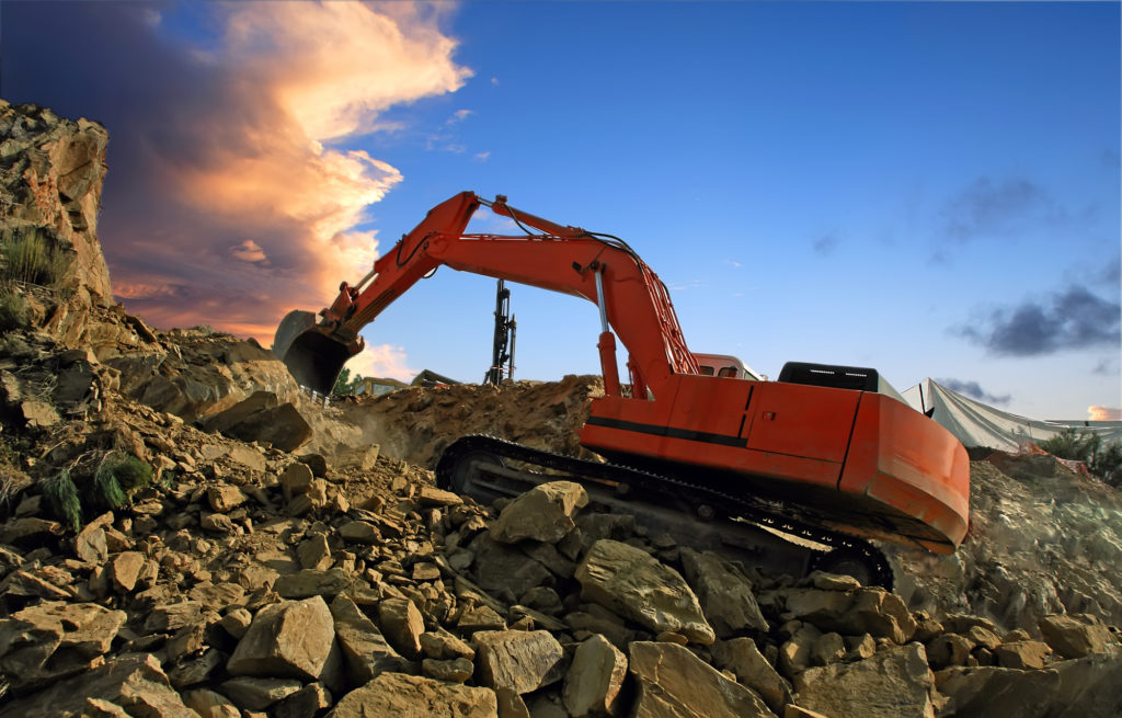 Excavator digging mountain by crushing rocks with its shovel
